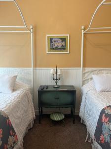 a bedroom with two beds and a table with a lamp at Terrace Inn and 1911 Restaurant in Petoskey