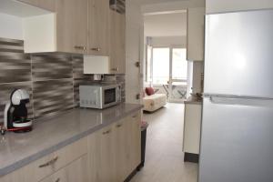uma cozinha com um frigorífico e um micro-ondas em Les Grandes Roches - Studio et balcon plage à pied em La Rudelière