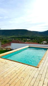 a swimming pool on top of a house with a wooden deck at Casa de Alcaria in Alcaria