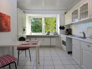 een witte keuken met een tafel en een raam bij Appartement Relax in Welferode mit Großer Terrasse in Welferode