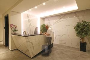 a man standing at a counter in a lobby at Kalevera Hotel in Edirne