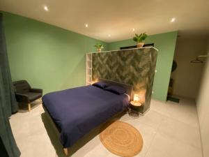 ein Schlafzimmer mit einem lila Bett und einem Stuhl in der Unterkunft Maison in Dalhem