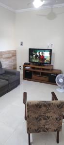 薩誇雷馬的住宿－Linda casa com piscina，一间带电视和沙发的客厅