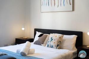 um quarto com uma cama com lençóis brancos e almofadas em Aircabin - Sydney Central Station - 1 Bed Studio em Sidney