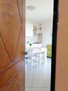 une porte menant à une cuisine avec une table et des chaises dans l'établissement Ferienwohnung für 4 Personen ca 60 qm in Lu Bagnu, Sardinien Anglona - b61135, à Castelsardo