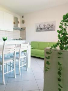 Il comprend une cuisine et un salon avec un canapé vert. dans l'établissement Ferienwohnung für 4 Personen ca 60 qm in Lu Bagnu, Sardinien Anglona - b61135, à Castelsardo