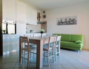 une cuisine avec une table et un canapé vert dans l'établissement Ferienwohnung für 4 Personen ca 60 qm in Lu Bagnu, Sardinien Anglona - b61135, à Castelsardo