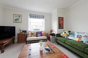 a living room with a green couch and a table at Viking Bay View 3 Bed Apartment in Broadstairs