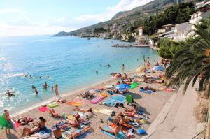 a group of people on a beach in the water at Prestige Apartments in Jesenice