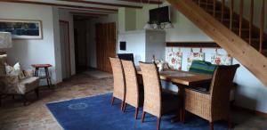 ein Esszimmer mit einem Holztisch und Stühlen in der Unterkunft Kleine Ferienwohnung in Bugewitz mit Garten, Terrasse und Grill in Bugewitz