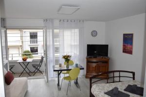 uma sala de estar com uma mesa e uma sala de jantar em Les Grandes Roches - Studio et balcon plage à pied em La Rudelière