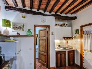 a kitchen with a wooden door and a refrigerator at Appartamento Il Caratello Borgo 6 in Capoliveri