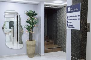 a potted plant in a hallway with a staircase at Hotel Place Jardin in Garanhuns