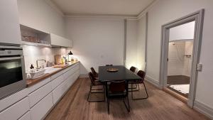 a kitchen with a table and chairs in a room at The Admirals Apartments - Carolinas apartments in Copenhagen