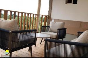 a balcony with a couch and chairs and a table at Hotel las marias de neiba in Cerro en Medio
