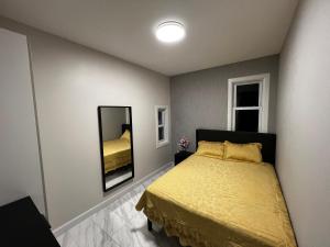 a bedroom with a yellow bed and a mirror at 3 bedrooms in Modern Brooklyn home, Close to J train in Brooklyn