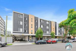 ウェントワースビルにあるAircabin - Wentworthville - 2 Beds Apt Free Parkの駐車場に車が駐車されている大きな建物