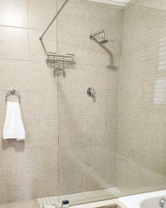 W łazience znajduje się prysznic ze szklanymi drzwiami. w obiekcie Waterlily Cove Guesthouse w mieście Pretoria