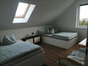 a attic bedroom with two beds and a window at Haus Am Meer in Mieroszyno