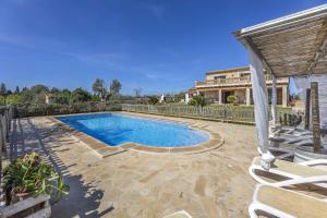 a swimming pool in a yard next to a house at Finca Sa Torreta in Santa Margalida