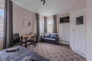 Una habitación de hotel con una cama, una silla y una mesa. en Dom Pracy Twórczej, en Świnoujście