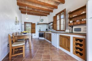 a large kitchen with wooden cabinets and a table at Finca Sa Torreta in Santa Margalida