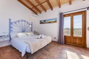 a bedroom with a bed and a balcony at Finca Sa Torreta in Santa Margalida