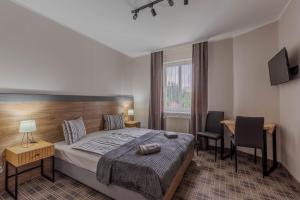 Un dormitorio con una cama, un escritorio y una silla. en Dom Pracy Twórczej, en Świnoujście