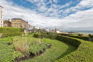 a garden with bushes and the ocean in the background at Viking Bay View 3 Bed Apartment in Broadstairs
