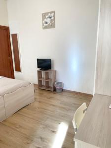 Habitación blanca con cama y TV en Casa di Magda2, en Reggio Calabria