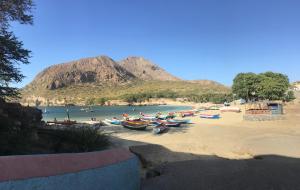 a group of boats on a beach with a mountain at Chez Lopes in Praia