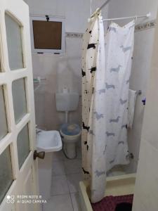 a bathroom with a toilet and a shower curtain with cows at Chez Lopes in Praia