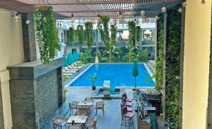 an outdoor patio with tables and chairs and a swimming pool at Imperial Resort Apartment XL 1 Bed in Hurghada