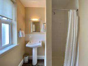 un baño con lavabo y ducha en Cottage 460 - Clifden, en Clifden 32 fotos más