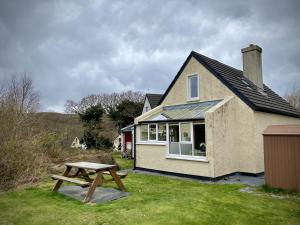 Una casa con una mesa de picnic delante de ella. en Cottage 460 - Clifden, en Clifden