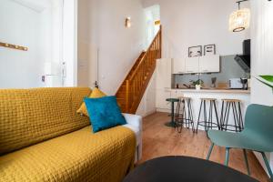 a living room with a yellow couch and a kitchen at Mon Appart'hôtel - Gare de Limoges - Charmant 1 et 2 Chambres Duplex - Parking en supp in Limoges