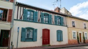un bâtiment avec des volets verts et une porte rouge dans l'établissement Mon Appart'hôtel - Gare de Limoges - Duplex 2 Chambres - Parking en supp, à Limoges