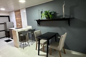 a dining room with a black table and chairs at Rio Aparta-Hotel 2 in Leticia