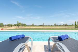 - deux chaises assises à côté de la piscine dans l'établissement Ferienhaus mit Privatpool für 8 Personen ca 430 qm in Felanitx, Mallorca Südostküste von Mallorca, à Felanitx