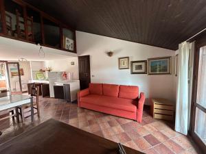 ein Wohnzimmer mit einem roten Sofa und einer Küche in der Unterkunft HARMONY HOUSE APARTMENT in Syrakus