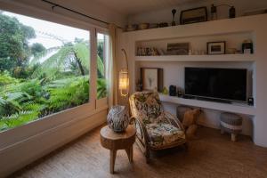 sala de estar con silla y ventana grande en Lake View House, en Sete Cidades