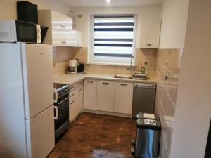 a small kitchen with white appliances and a window at Haus Am Meer in Mieroszyno