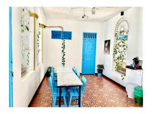 聖瑪爾塔的住宿－Kasaya Hotel，一间带桌子和蓝色椅子的用餐室