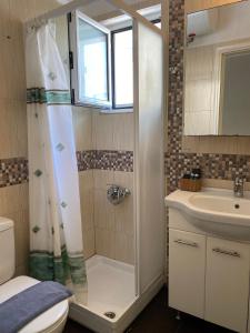a bathroom with a shower and a sink at Bright and cozy apartment near the city center in Zakynthos Town