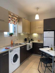 a kitchen with a washer and a sink and a dishwasher at Bright and cozy apartment near the city center in Zakynthos Town