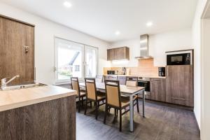 a kitchen with wooden cabinets and a table and chairs at Zehnthof Apartment WH1 in Pulheim