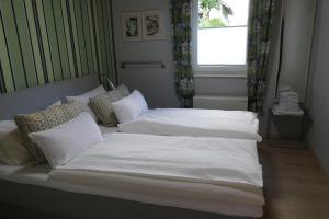1 Schlafzimmer mit 2 Betten mit weißer Bettwäsche und einem Fenster in der Unterkunft Landleben - Ferienhaus 2 in Fritzlar