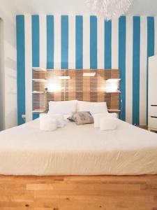 a bedroom with a large bed with blue and white stripes at Palermo Central B&B in Palermo