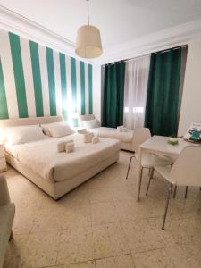 sala de estar con 2 camas y cortinas verdes en Palermo Central B&B, en Palermo