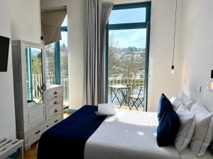 um quarto com uma cama e uma janela grande em Des Arts em Amarante